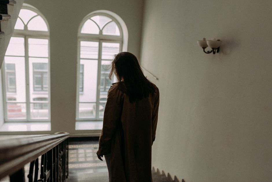明るい建物の階段を降りる女性