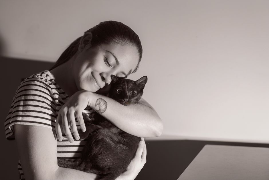 黒猫を抱きしめる女性