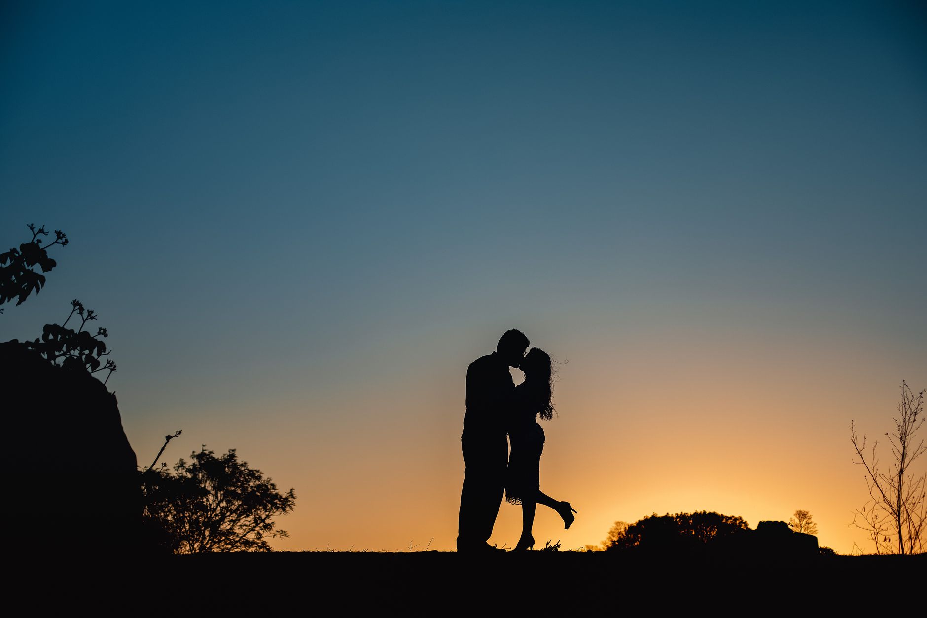 夕日の丘で抱き合う二人のシルエット