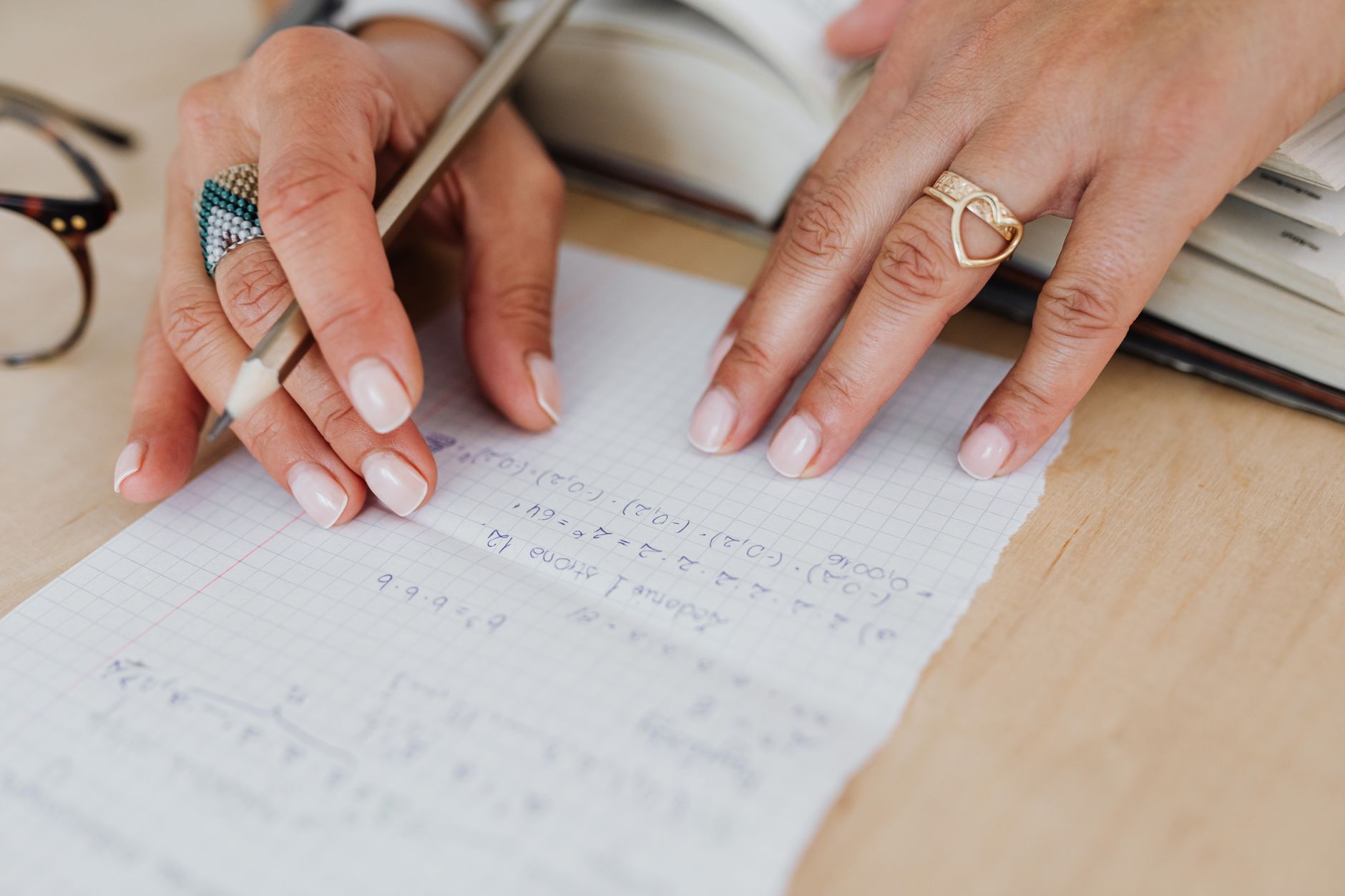 方眼のノートに数字を書き出す女性