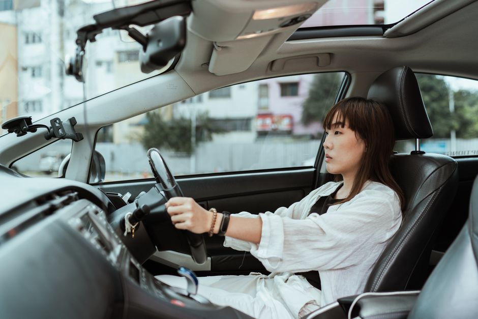 街なかで車を運転する女性