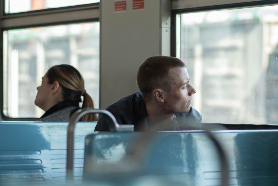 電車の窓の外を眺める人