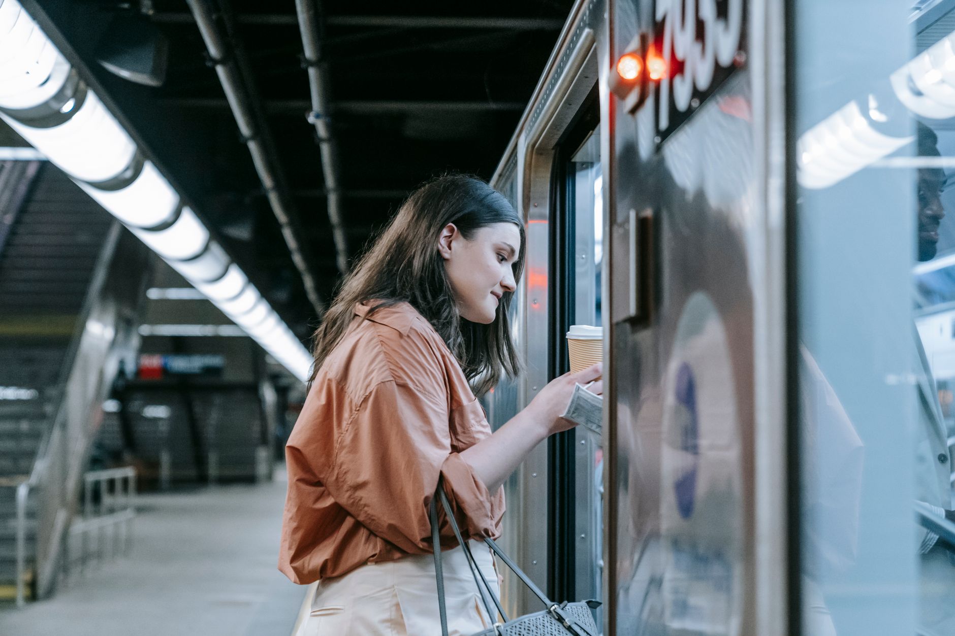 駅のホームで電車に乗り込もうとする女性
